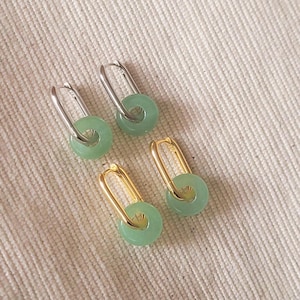 Elegant green jade hoop earrings with gold accents, 
 subtle yet sophisticated design.