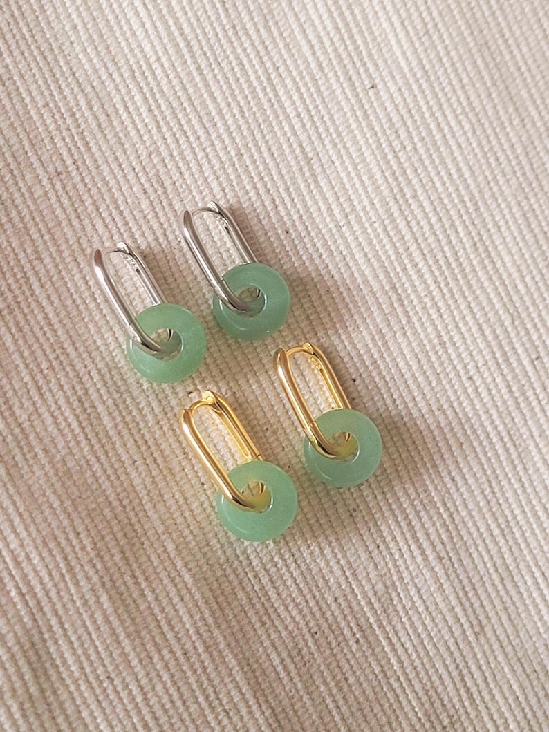 Elegant green jade hoop earrings with gold accents, 
 subtle yet sophisticated design.