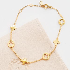This Gold Clover Bracelet features a delicate four leaf clover charms, symbolizing good luck and prosperity. Crafted with 18k gold plated sterling silver, ideal for birthdays or anniversaries.