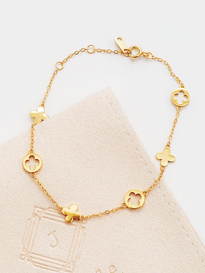 This Gold Clover Bracelet features a delicate four leaf clover charms, symbolizing good luck and prosperity. Crafted with 18k gold plated sterling silver, ideal for birthdays or anniversaries.