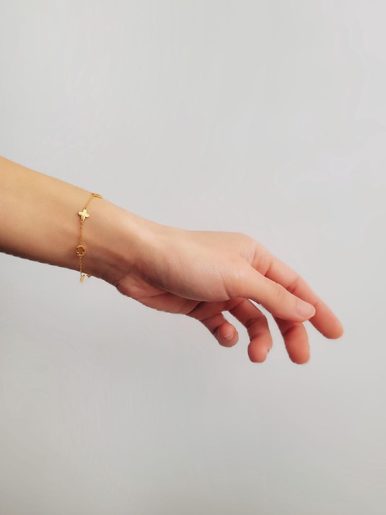 This Gold Clover Bracelet features a delicate four leaf clover charms, symbolizing good luck and prosperity. Crafted with 18k gold plated sterling silver, ideal for birthdays or anniversaries.