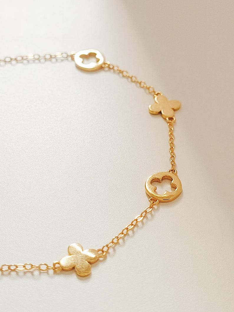 This Gold Clover Bracelet features a delicate four leaf clover charms, symbolizing good luck and prosperity. Crafted with 18k gold plated sterling silver, ideal for birthdays or anniversaries.