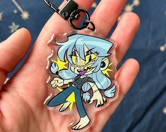 May include: A clear acrylic keychain featuring a cartoon character with light blue hair, stitched facial features, and a black outfit. The character has a yellow background with lightning bolts and a black metal clasp.