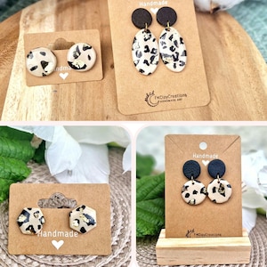 Könnte beinhalten: Drei Paar handgefertigte Ohrringe mit einem schwarz-weißen Leopardenmuster mit goldenen Akzenten. Die Ohrringe werden auf braunem Karton mit dem Wort "Handmade" darauf präsentiert.
