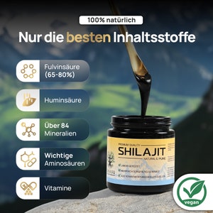 May include: A black jar with a gold label that reads "Premium Quality Shilajit Natural & Pure". The jar is filled with a thick, black substance. The label also includes the text "Labor Getestet", "Mehrfach Sorgfaltig Gereinigt", and "Aus Verantwortungsvollen Quellen". The jar is sitting on a brown surface with a green leaf icon that says "vegan".