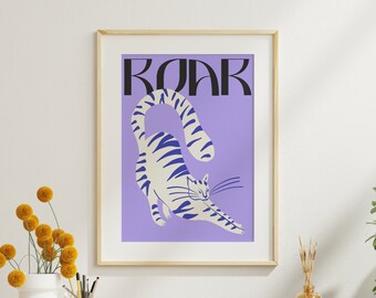 Puede incluir: Una impresión enmarcada con un fondo morado y un gato rayado blanco y azul estirándose con la palabra "ROAR" en letras negras sobre el gato.