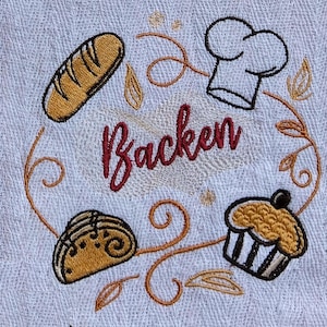 Könnte beinhalten: Weißes, besticktes Küchentuch mit Backmotiv. Es zeigt ein Brot, eine Kochmütze, einen Muffin und ein Gebäck, alles in einem kreisförmigen Design um das Wort "Backen" in burgunderfarbener Schrift. Das Design ist in Braun- und Schwarztönen gehalten.