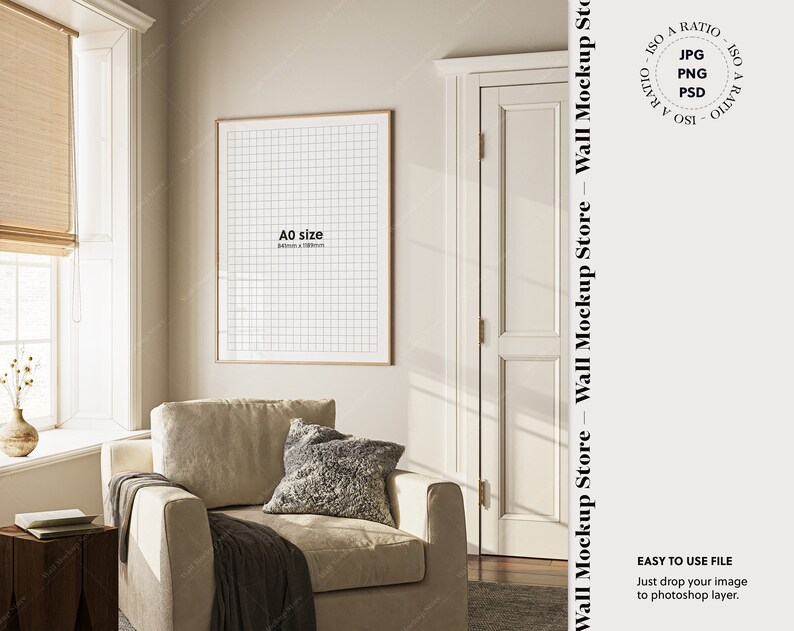 May include: A beige armchair with a gray throw blanket and a gray pillow sits in a room with a large window and a framed print on the wall. The print is labeled "A0 size".