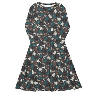 May include: A long-sleeved dress featuring a dark grey backdrop adorned with a repeating pattern of Halloween characters. The design incorporates ghosts, bats, and other spooky creatures in white, brown, and teal.