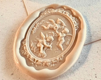 Può includere: Una collezione di sigilli di cera decorativi in vari colori e design. I sigilli presentano figure di cherubini e cornici ornate. I colori includono rosa, verde, marrone e crema. I sigilli sono ovali e circolari.