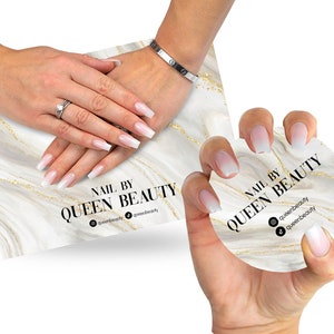 Peut inclure: Des pointes d'ongles ombrées blanches et rose clair avec une pointe blanche sur un fond en marbre. Le texte "Nail by Queen Beauty" est imprimé sur la carte. Les poignées de médias sociaux sont également incluses : @queenbeauty et queenbeauty.