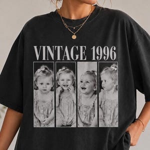 Può includere: T-shirt nero con la scritta "VINTAGE 1996" sopra una serie di quattro foto in bianco e nero di una bambina. La maglietta è oversize e ha maniche corte.