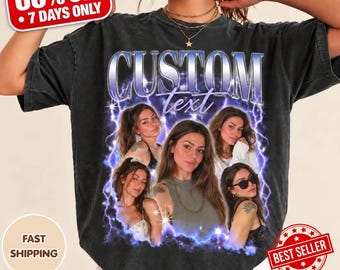 May include: A charcoal gray short-sleeve t-shirt featuring a graphic print with the text CUSTOM text in a metallic blue font. The design includes three photographic portraits of a person surrounded by purple and blue lightning effects.