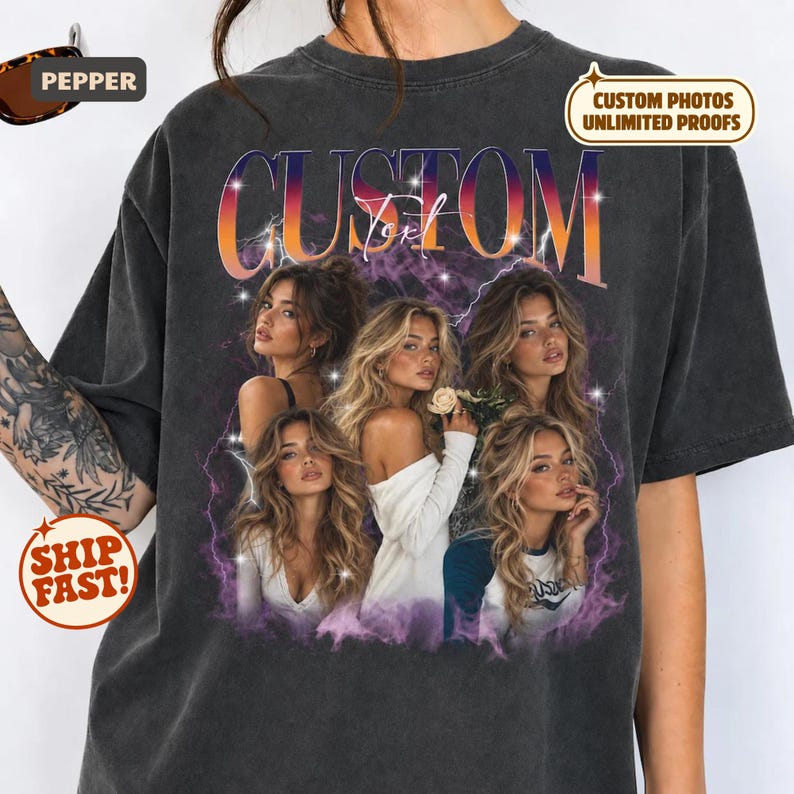 May include: A charcoal gray short-sleeve t-shirt featuring a large graphic print with the word CUSTOM in bold orange and purple gradient letters. The design includes four portraits of a woman with long blonde hair, surrounded by purple lightning and star accents.