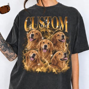 May include: A charcoal gray short-sleeve t-shirt featuring a graphic print of four golden retriever dogs surrounded by golden lightning and smoke effects. The word CUSTOM is printed in large gold letters at the top with the word Text below it.