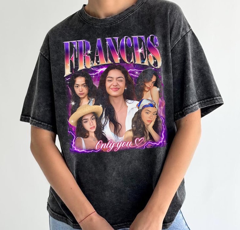 May include: Dark gray t-shirt featuring a graphic of a woman with the name "FRANCES" in a purple and orange font. The graphic includes multiple images of the woman and the text "Only you" with a heart symbol. The shirt has a vintage, washed appearance.