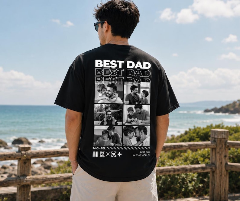 Puede incluir: Camiseta negra con las palabras "BEST DAD" en letras blancas. La parte posterior de la camiseta presenta un collage de fotos en blanco y negro. La camiseta tambi&eacute;n tiene las palabras "BEST DAD IN THE WORLD".