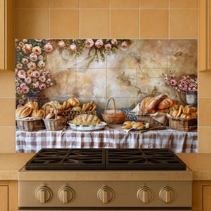 May include: A kitchen splashback depicting a still life of baked goods. Baskets and plates hold croissants, loaves of bread, and pastries. A checkered tablecloth and floral accents complete the scene.