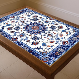 May include: A rectangular wooden coffee table with a decorative tile top. The tile features a white background with a blue floral pattern and red accents. The table has a dark brown wooden frame and legs.