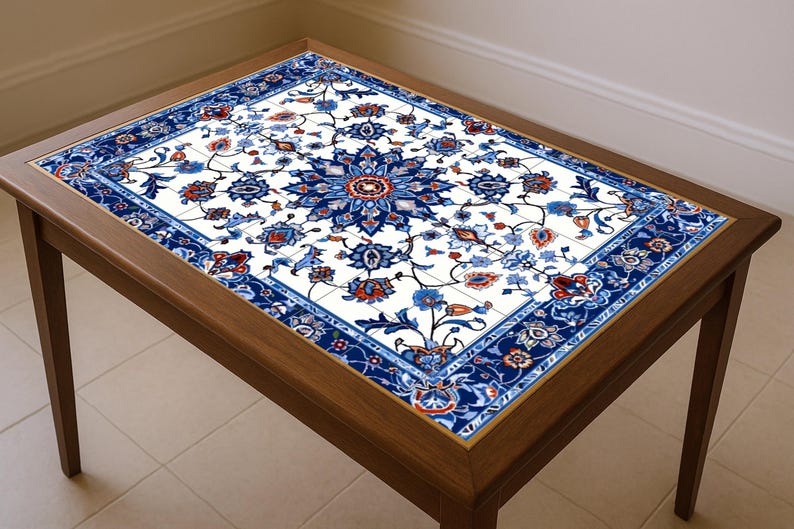May include: A rectangular wooden coffee table with a decorative tile top. The tile features a white background with a blue floral pattern and red accents. The table has a dark brown wooden frame and legs.