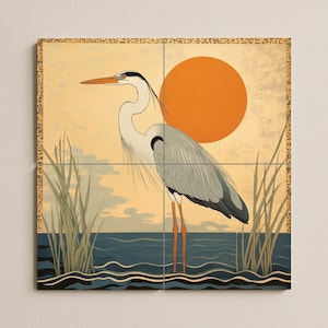 May include: An art print depicting a heron in a waterscape. The heron has grey and white plumage, long orange legs, and a long orange beak. An orange sun is in the background, and the water is dark blue. Reeds are in the foreground.