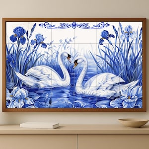 Può includere: Un'opera d'arte incorniciata con un disegno di cigni blu e bianchi. L'immagine raffigura due cigni in uno stagno, circondati da iris blu e erba alta. La cornice è di colore marrone scuro.