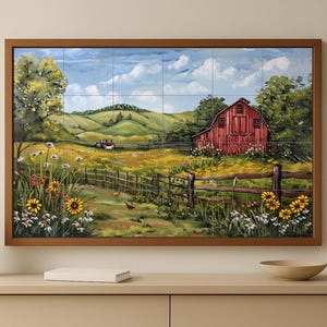 Puede incluir: Pintura enmarcada de un paisaje rural con un granero rojo, colinas verdes y una valla de madera. La obra de arte incluye flores silvestres y un cielo azul con nubes. La pintura se exhibe en un mueble de color claro.