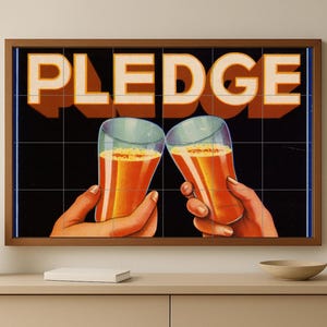 Op de afbeelding: Een ingelijste print met het woord "PLEDGE" boven twee handen die proosten met glazen amberkleurige vloeistof. De achtergrond is zwart met een rasterpatroon. De print heeft een bruine lijst.