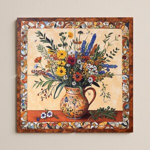 May include: A floral still life painting featuring a vibrant bouquet of colorful flowers in an orange ceramic pitcher. The pitcher is decorated with blue floral patterns. The artwork is framed with a decorative border and set against a light beige background.