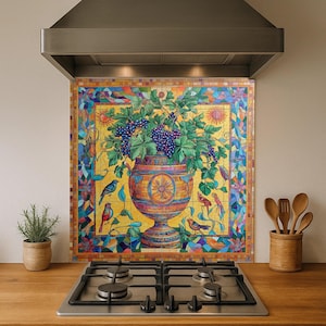 May include: A colorful kitchen backsplash featuring a mosaic design with a large vase filled with grapes and foliage. The artwork includes birds, suns, and floral elements, set against a yellow background. The backsplash is installed above a gas stove.