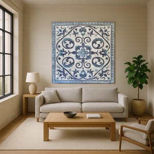 Peut inclure: Une grande œuvre d'art murale carrée avec un motif floral bleu et blanc est suspendue au-dessus d'un canapé beige. L'œuvre présente un motif floral central entouré de motifs tourbillonnants. La pièce a une palette de couleurs neutres.