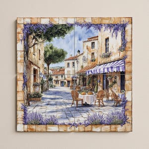 Può includere: Un set di piastrelle decorative raffiguranti una scena di strada europea. L'immagine presenta edifici con tetti di tegole rosse, una tenda a strisce blu e bianca e tavoli con sedie. Fiori di lavanda incorniciano la scena.