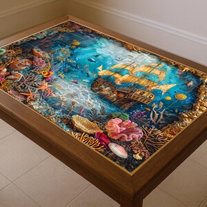 May include: A rectangular wooden coffee table with a detailed underwater scene on the tabletop. The scene features a sunken ship, coral, and marine life in shades of blue, gold, and red. The table has a dark brown frame and legs.