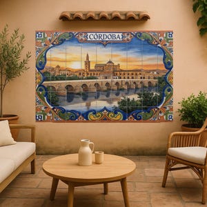 Puede incluir: Un mural de azulejos coloridos que representa una puesta de sol sobre una ciudad con un puente y un río, con la palabra "CORDOBA" en la parte superior. El mural está enmarcado por un borde decorativo. La escena está ambientada en un patio exterior con muebles.