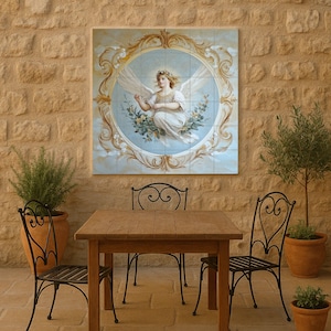 Könnte beinhalten: Ein Wandkunstwerk mit einem Gemälde eines Engels mit Flügeln in einem goldenen Rahmen. Der Engel trägt weiße Gewänder und ist von Blumen und Wolken umgeben. Das Kunstwerk hängt an einer Steinmauer über einem Holztisch und schmiedeeisernen Stühlen.