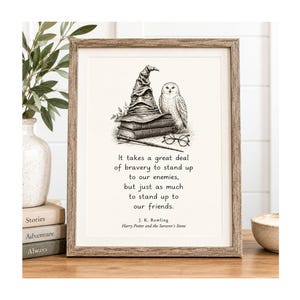 May include: A framed print featuring a black and white illustration of a wizard hat, an owl, books, and glasses. The text reads: It takes a great deal of bravery to stand up to our enemies, but just as much to stand up to our friends. J. K. Rowling.
