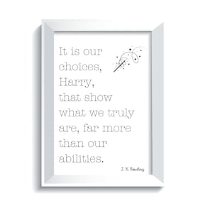 May include: A framed print with a white border features a quote from J.K. Rowling: "It is our choices, Harry, that show what we truly are, far more than our abilities." The text is in a simple, clean font, accompanied by a wand and star illustration.
