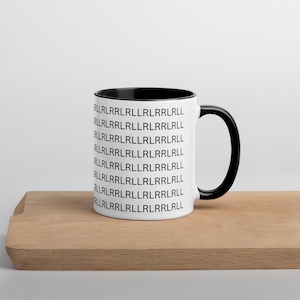 May include: A white ceramic mug with a black interior and handle. The mug is printed with a repeating pattern of black text. The mug is sitting on a wooden surface.