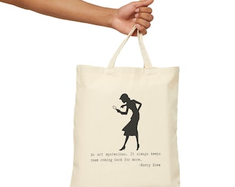 May include: Cream-colored tote bag featuring a black silhouette of a woman holding a magnifying glass. The bag has the quote "Do act mysterious. It always keeps them coming back for more." by Nancy Drew.