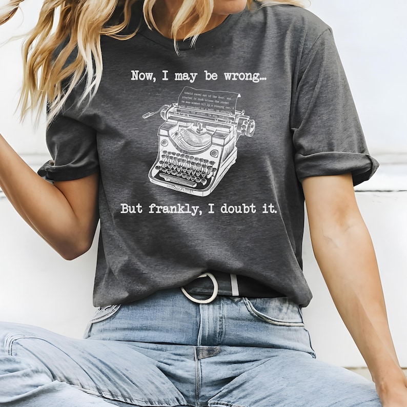 May include: A dark gray t-shirt with a white vintage typewriter graphic and the text "Now, I may be wrong... But frankly, I doubt it."