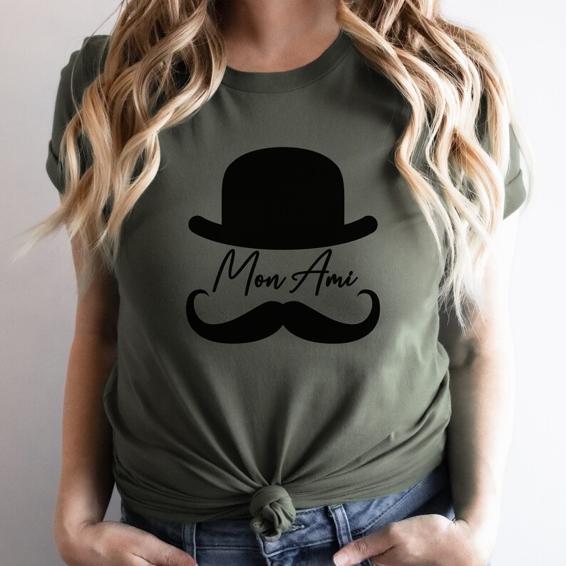 May include: A green t-shirt with a black bowler hat and mustache graphic and the text "Mon Ami".