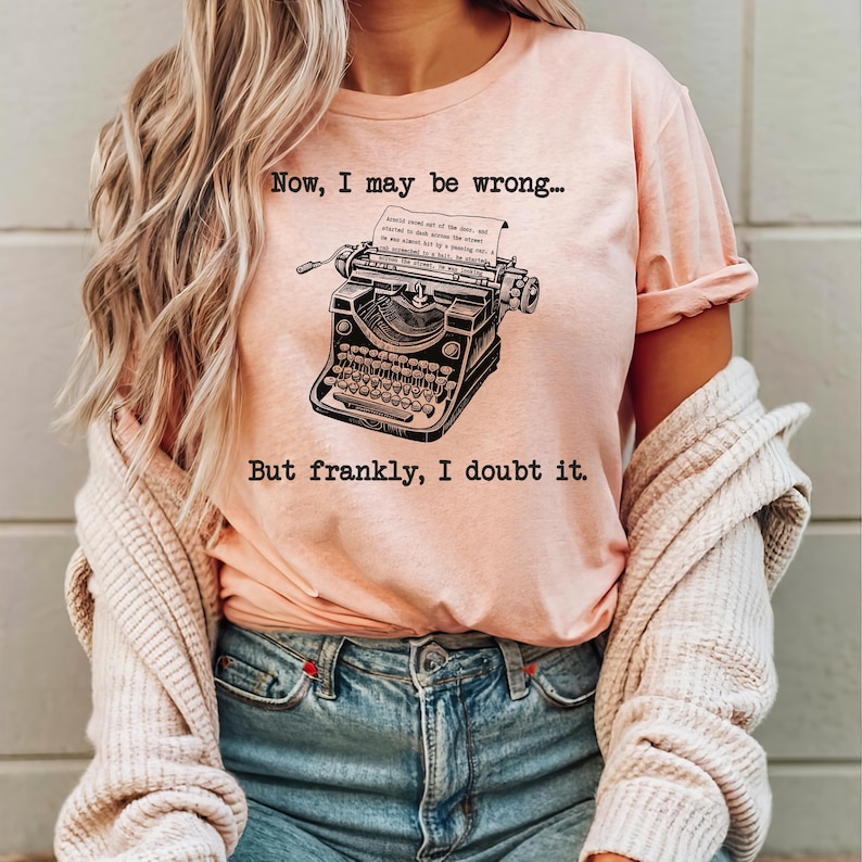 May include: A pink t-shirt with a vintage typewriter graphic and the text "Now, I may be wrong... But frankly, I doubt it."