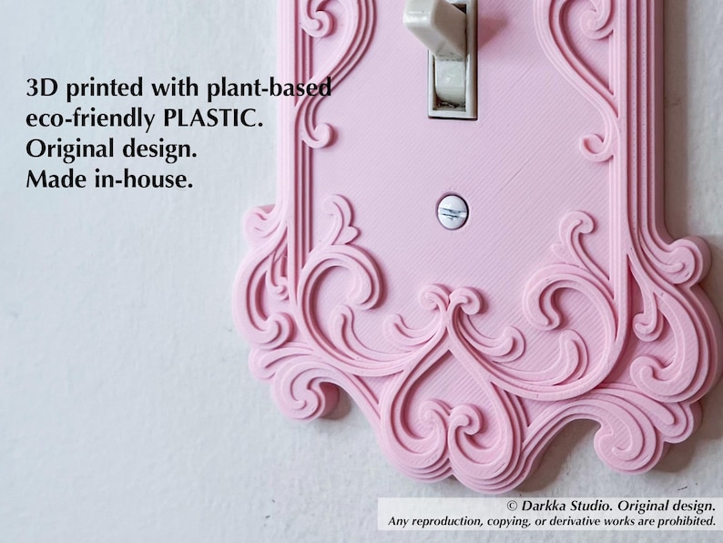 Puede incluir: Una placa de interruptor de luz rosa impresa en 3D con un dise&ntilde;o ornamental y arremolinado. La cubierta est&aacute; hecha de pl&aacute;stico de origen vegetal y presenta un interruptor basculante est&aacute;ndar. El texto en la cubierta dice "3D printed with plant-based eco-friendly PLASTIC."