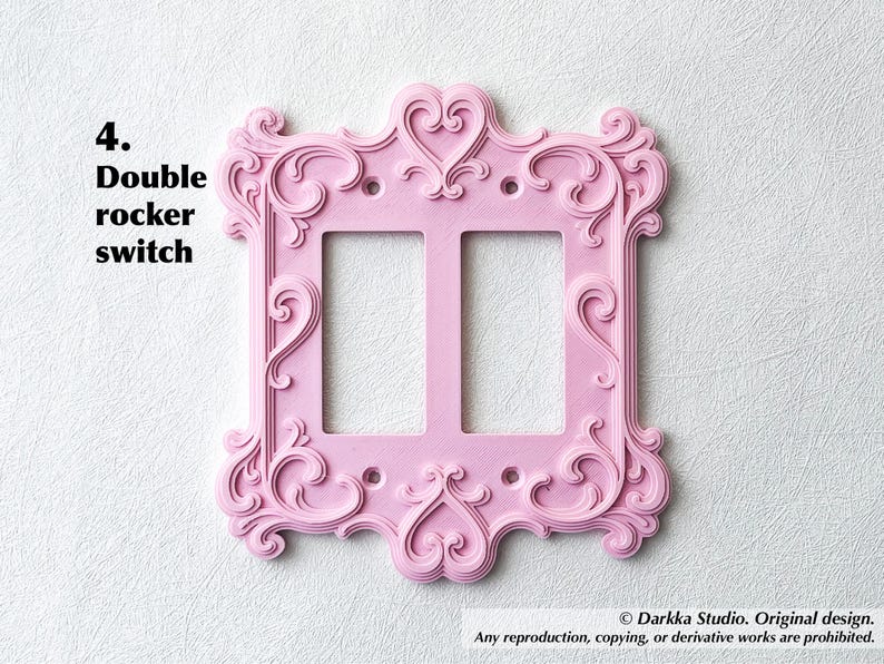 Puede incluir: Una placa de interruptor basculante doble rosa con detalles ornamentados y arremolinados y acentos en forma de coraz&oacute;n. La placa tiene dos aberturas para interruptores y el texto "4. Double rocker switch".