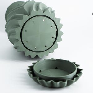 K&ouml;nnte beinhalten: Salbeigr&uuml;ner, 3D-gedruckter Pflanztopf mit einem einzigartigen Spiraldesign. Der Pflanztopf hat einen kreisf&ouml;rmigen Boden mit Abzugsl&ouml;chern und einen passenden Einsatz. Das Design enth&auml;lt das Logo "Factorian Designs".