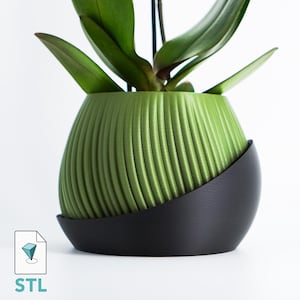 May include: A green, ribbed planter with a black, curved base, holding a green plant with long leaves. The planter has a modern design. The image also includes an "STL" icon.