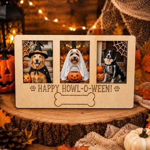 May include: A rectangular light-colored wooden picture frame with three vertical photo slots. The frame features laser-engraved spider web corners, the text "HAPPY HOWL-O-WEEN!" with paw prints, and a large bone-shaped cutout at the bottom.