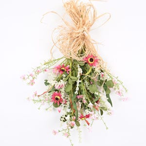 May include: A bouquet of pink and white artificial flowers tied with natural twine. The flowers are arranged in a cascading style, with the stems extending downwards.