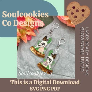 May include: Two clear acrylic keychains with a bird skull, butterfly, and greenery inside a glass dome. The keychains have silver hooks. The image includes the text "Soulcookies Co Designs" and "This is a Digital Download SVG PNG PDF."