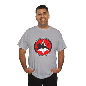 May include: A gray t-shirt with a red circle graphic featuring a black fighter jet and the text "Robotech Defense Force Veritech VF-1 Fighter Squadron".